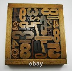 29 pieces vintage/antique letterpress wood type numbers in a frame withstand