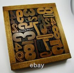 29 pieces vintage/antique letterpress wood type numbers in a frame withstand