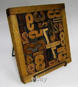 29 pieces vintage/antique letterpress wood type numbers in a frame withstand