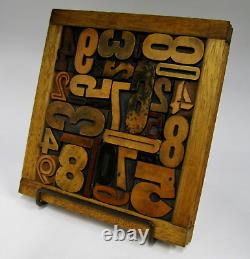 29 pieces vintage/antique letterpress wood type numbers in a frame withstand