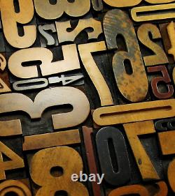 29 pieces vintage/antique letterpress wood type numbers in a frame withstand