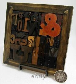 33 pcs. Vintage/antique letterpress in a stained wood frame with black stand