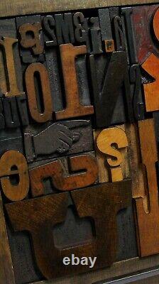 33 pcs. Vintage/antique letterpress in a stained wood frame with black stand