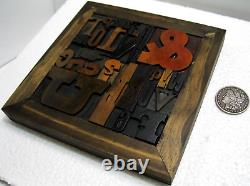 33 pcs. Vintage/antique letterpress in a stained wood frame with black stand