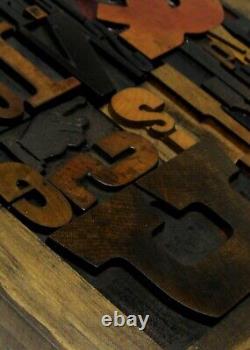 33 pcs. Vintage/antique letterpress in a stained wood frame with black stand