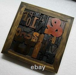33 pcs. Vintage/antique letterpress in a stained wood frame with black stand
