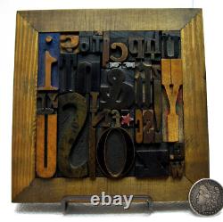 35 pcs. Vintage/antique letterpress in a stained wood frame with brown stand