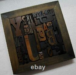 36 pcs. Vintage/antique letterpress in stained wood frame with square iron stand