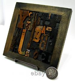36 pcs. Vintage/antique letterpress in stained wood frame with square iron stand