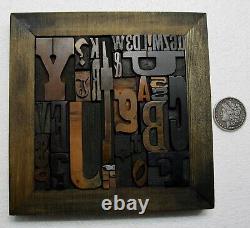 36 pcs. Vintage/antique letterpress in stained wood frame with square iron stand