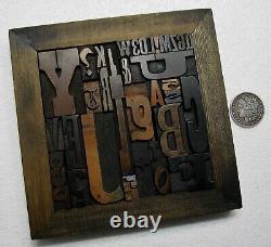 36 pcs. Vintage/antique letterpress in stained wood frame with square iron stand