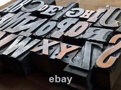 Mélange éclectique de blocs d'impression en métal et en cuivre antiques de l'alphabet complet de 26 lettres